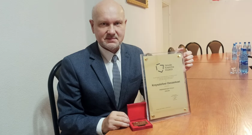 Krzysztof Owczarek, przewodniczący rady powiatu wieluńskiego prezentuje odznaczenie/fot.: Magdalena Lizurej