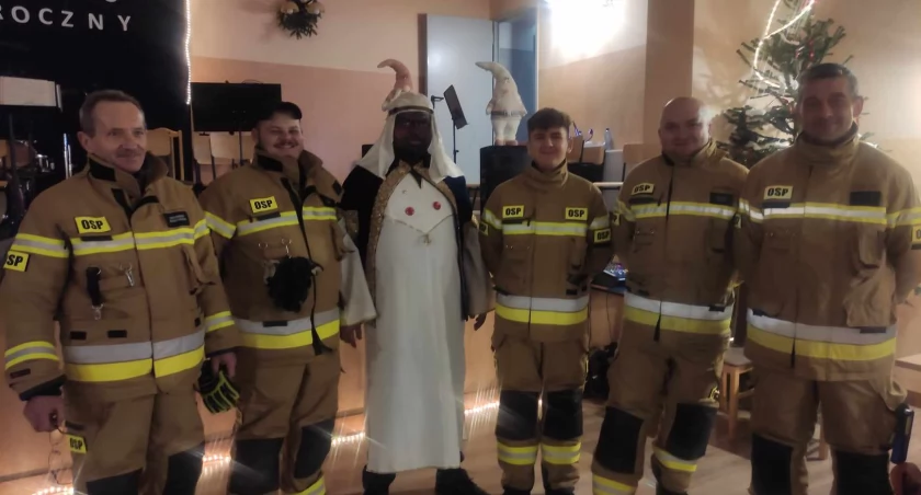 Tak prezentują się skomlińscy strażacy ochotnicy w nowych ubraniach specjalnych. Na zdjęciu: ze swoim prezesem Grzegorzem Perką, który w trakcie niedawnego koncertu tamtejszej strażackiej orkiestry dętej był przebrany za jednego z trzech mędrców/fot.: Ela Wodecka   