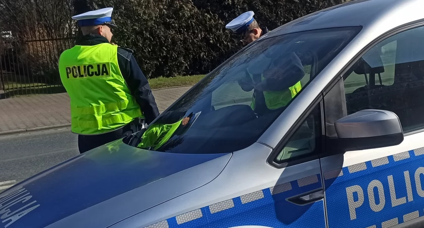 zdjęcie radiowozu i dwóch policjantów/fot.: Magdalena Lizurej/zdjęcie poglądowe