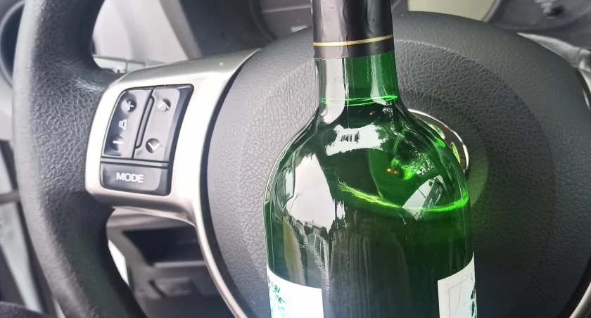 zdjęcie kierownicy i butelki alkoholu/fot.: Magdalena Lizurej