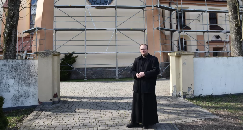 zdjęcie proboszcza parafii w Ostrówku ks. Pawła Otręby na tle remontowanego kościoła/fot.: Magdalena Lizurej