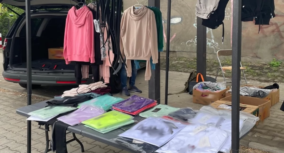 Na zdjęciu jedno ze stoisk na targowisku, na którym sprzedawano odzież z podrobionymi znakami towarowymi / Fot. KAS Łódź