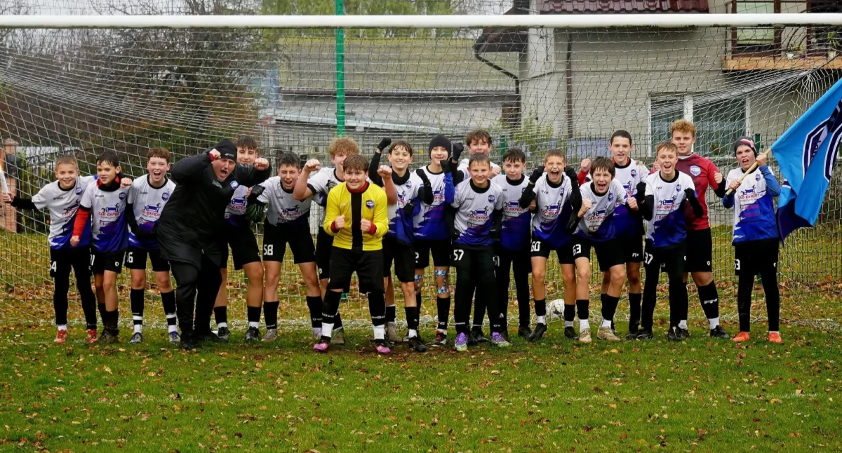 Na zdjęciu piłkarze Akademii Sportu Pajęczno z rocznika 2012 świętujący awans do I ligi wojewódzkiej wraz z trenerem Michałem Kostarczykiem /fot. Akademia Sportu Pajęczno 