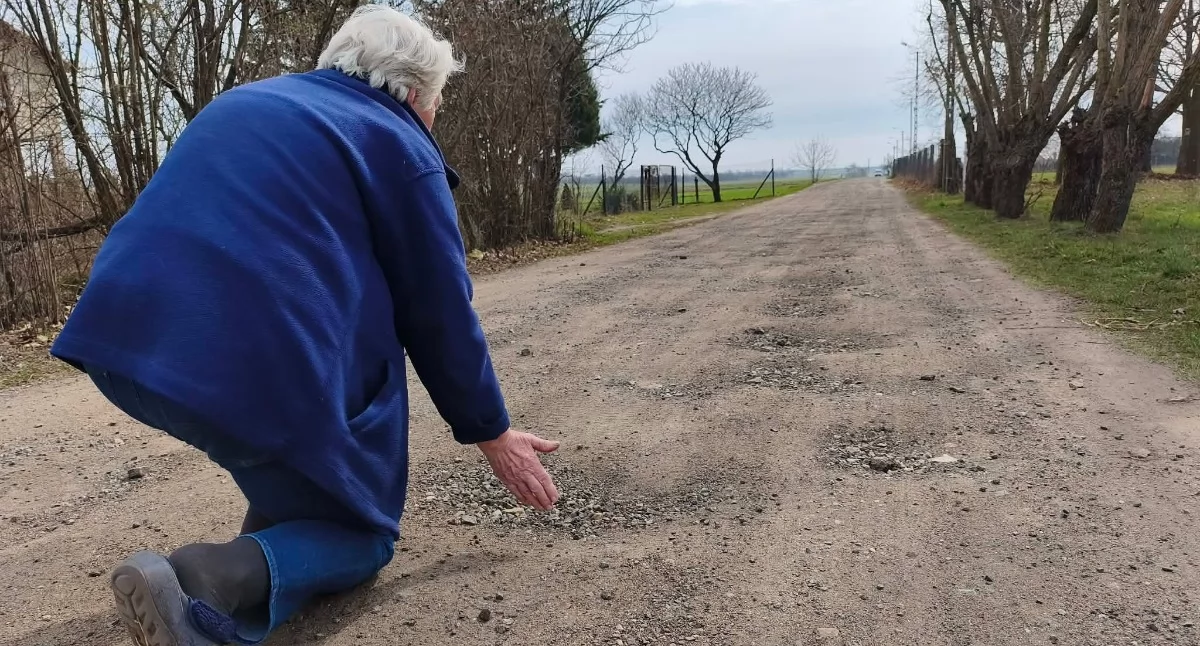 Na zdjęciu mieszkanka Gaszyna pokazuje fatalny stan ulicy Granicznej / fot.: Joanna Major