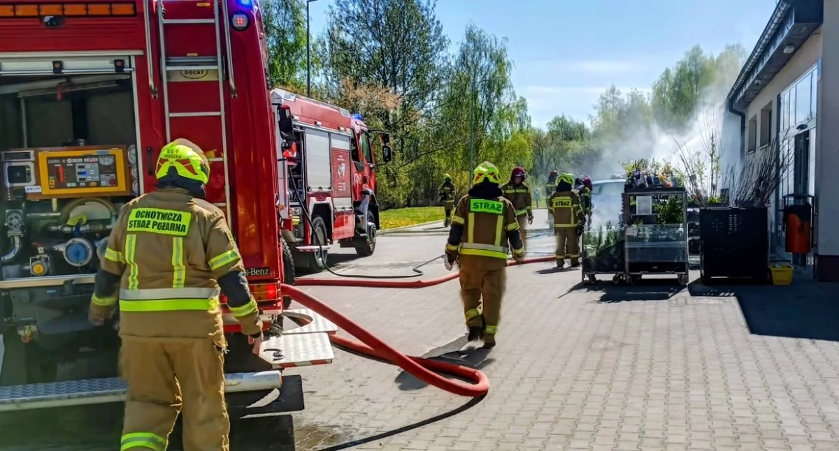 Na zdjęciu akcja ratowniczo-gaśnicza strażaków. Pożar auta przed marketem Dino w Praszce / fot.: KP PSP Olesno